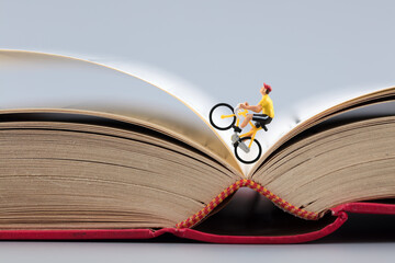 Macro scene cyclist on open book - Powered by Adobe