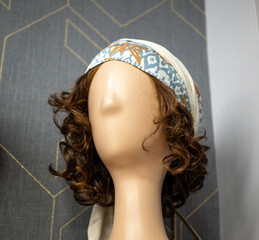 Vertical shot of a wig with a bandana on display