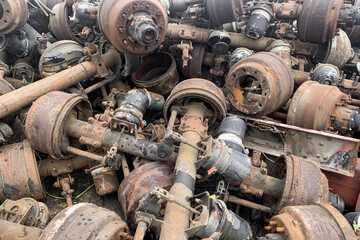 Pile of old rusty truck axle for reusing, used automotive part for sale, old rear differential of...