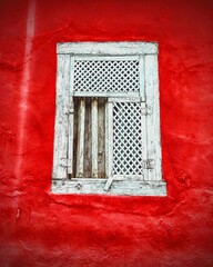 old window in red wall