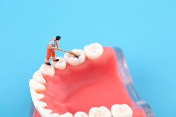Miniature creative worker cleaning mouth and teeth