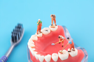 Miniature creative worker cleaning mouth and teeth