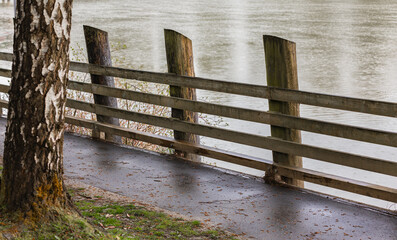 Path with wooden fence, walkway in the park by a river. Trail path in the park in Canada