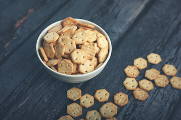 Crispy baked salted biscuits in white bowl	
