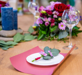 Festive wedding table setting with pink flowers,  glasses and candles, bright summer table decor.