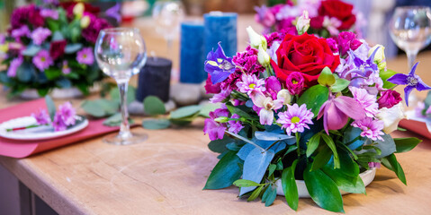 Beautiful table setting with crockery and flowers for a party, wedding reception or other festive event. Glassware and cutlery for catered event dinner.