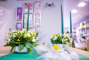 Beautiful table setting with flowers for a party, wedding reception or other festive event. Glassware and cutlery for catered event dinner.