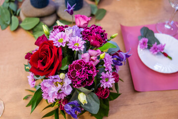 Beautiful table setting with crockery and flowers for a party, wedding reception or other festive event. Glassware and cutlery for catered event dinner.