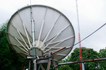 Behind a large satellite dish, natural background.