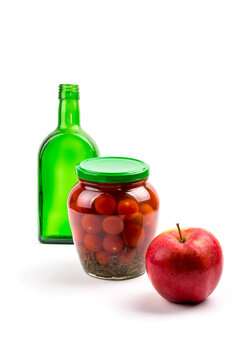 Still life with a green bottle, canned tomatoes and an apple