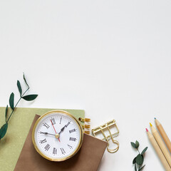 Notebook, pencil, clip, clock on white background. flat lay, top view, copy space
