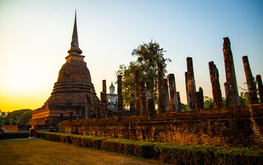 Obraz premium Sunset at Wat Mahathat buddha and temple in Sukhothai Historical Park