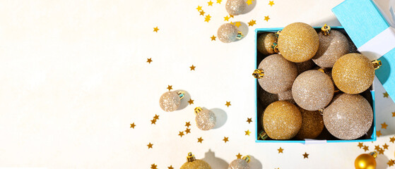 Box full of beautiful Christmas balls on light background with space for text, top view