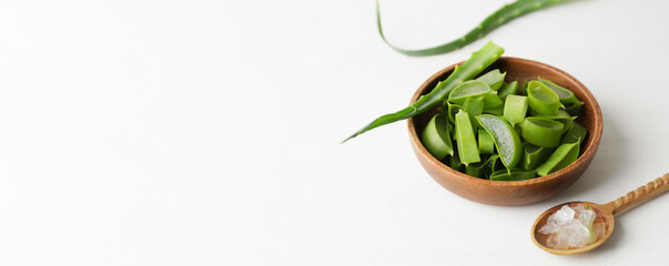 Spoon and plate of fresh cut aloe vera on white background with space for text