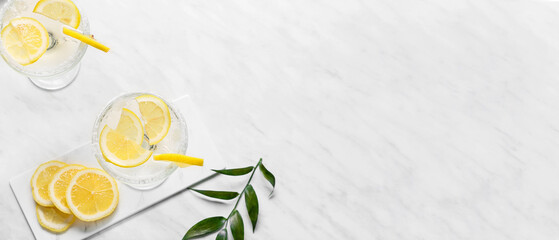 Glasses of tasty martini cocktail with lemon on light background with space for text, top view