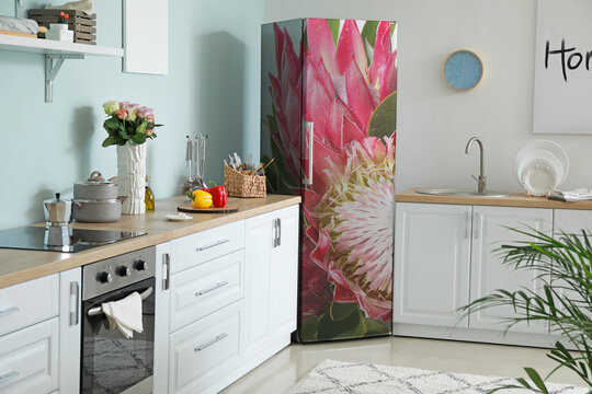 Refrigerator with print of tropical flowers in interior of modern kitchen