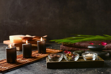 Spa composition with burning candles on dark background