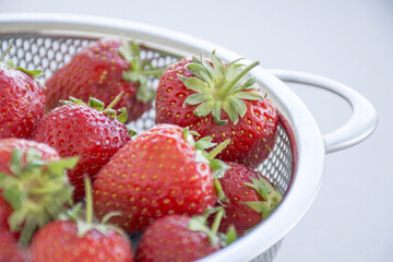 Closeup shot of freshly washed strawberries in a mesh strainer