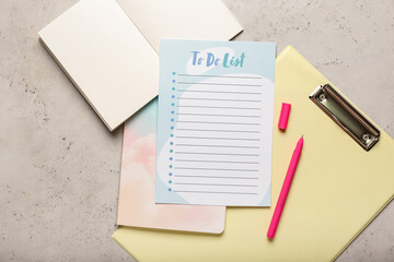 Blank to do list, opened notebook, clipboard and pen on grunge background