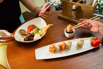 woman eating sushi in cafe