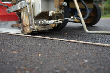 Blurred image, white traffic marking work on paved road
