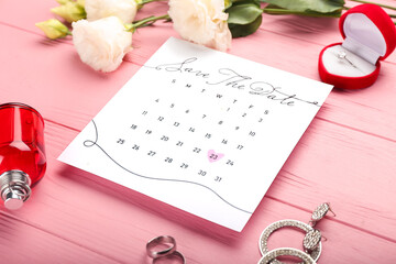 Wedding calendar with marked date and female accessories on color wooden table