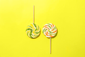 Sweet lollipops on yellow background