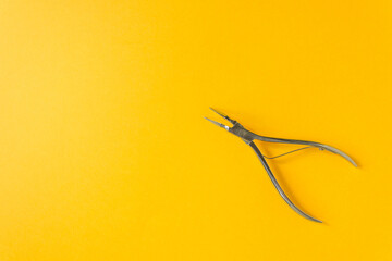 Open dental forceps for removing the root of the tooth isolated on the yellow background. Dental care and vet medicine.