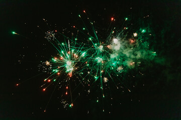 Beautiful view of red and green fireworks on a background of a night sky