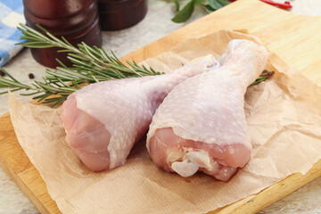 Raw chicken leg over board