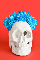 Human skull with flowers on red background