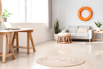 Interior of modern living room with lifebuoy, sofa and workplace