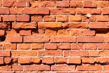 A fragment of an old red brick wall on a sunny day