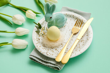 Stylish table setting for Easter celebration with tulip flowers on turquoise background