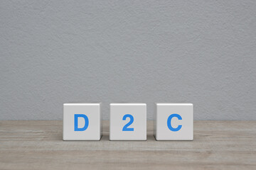 D2C letter on white block cubes on wooden table over white wall background, Direct to consumer concept