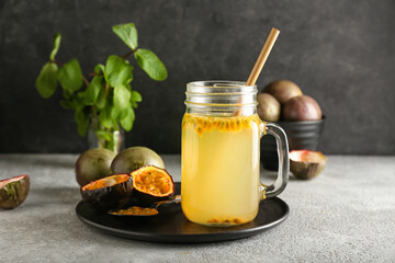 Mason jar of delicious passion fruit juice on dark background