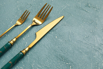 Golden cutlery on grey background