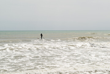 Fototapeta na wymiar Silhouette of a man practising paddle surf. 
