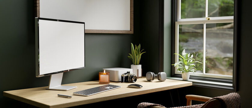 Modern contemporary home workspace with pc computer on table over dark green wall