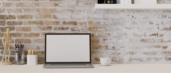 Minimal vintage workspace with laptop computer on white table over brick wall.