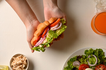 A female hands with healthy chicken croissant