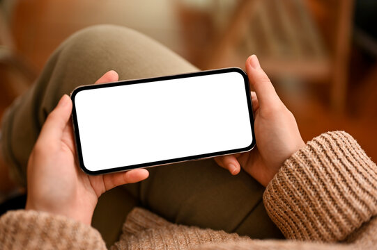 A mockup of horizontal smartphone white screen in a woman's hands.