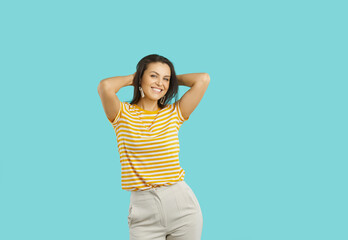 Studio portrait of beautiful woman. Beautiful carefree young woman with a charming cute smile posing on a turquoise background. Brunette woman in summer casual clothes smiling looking at camera.