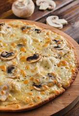 Homemade Pizza with champignons and mozzarella cheese on a wooden background close-up. Vertical orientation, close-up, no people