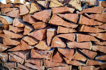 Natural texture of woodpile from coniferous trees. Pine firewood stacked on top of each other on a sunny day. Preparation of natural fuel.