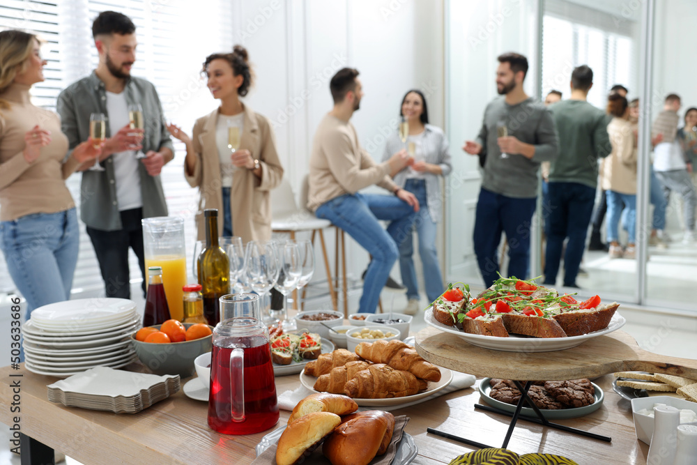 Sticker Brunch table setting with different delicious food.and blurred view of people on background