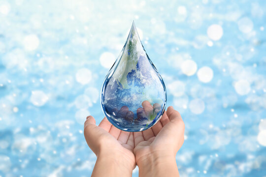 World Water Day. Woman holding icon of drop with Earth image inside on blurred background, closeup