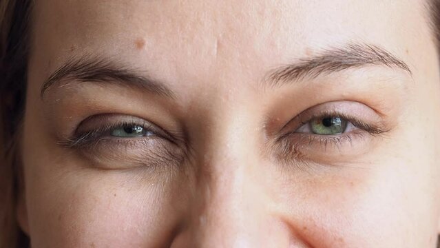 Close up smiling green eyes of a young beautiful woman.
