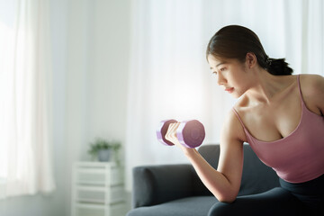 Fototapeta na wymiar stress relief, , breathing exercises, meditation, portrait of Asian healthy woman lifting weights to strengthen her muscles after work.