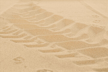 Car tire tracks on beach sand, closeup